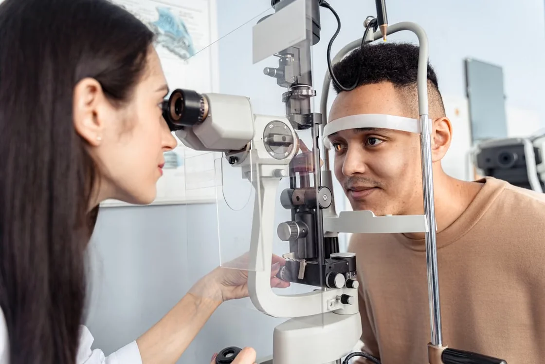 Eye care professional examining a patient using a slit lamp