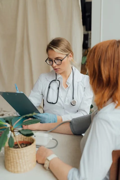 Physician reviewing a clipboard during a primary care consultation