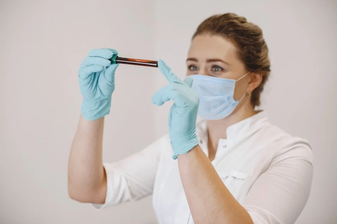 Laboratory professional examining a blood sample tube