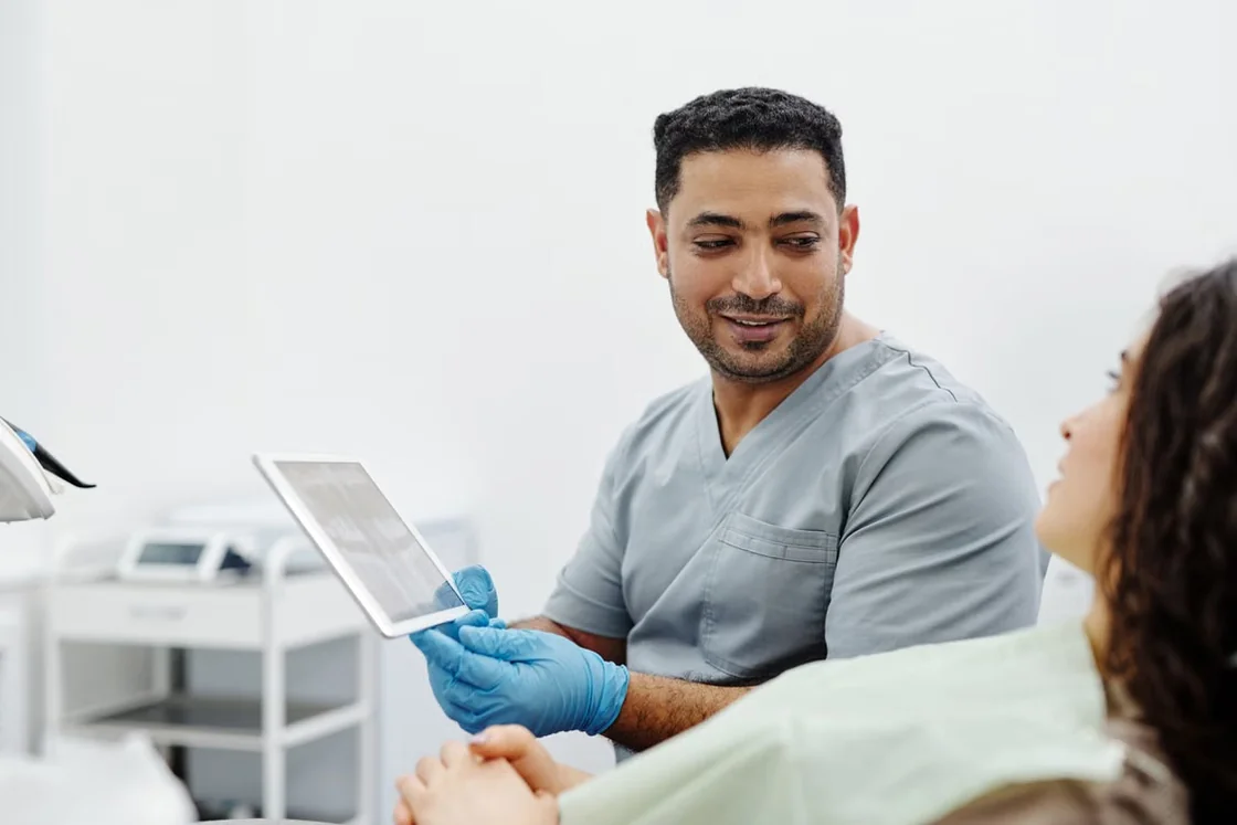 Clinician reviewing information on a tablet during a patient consultation